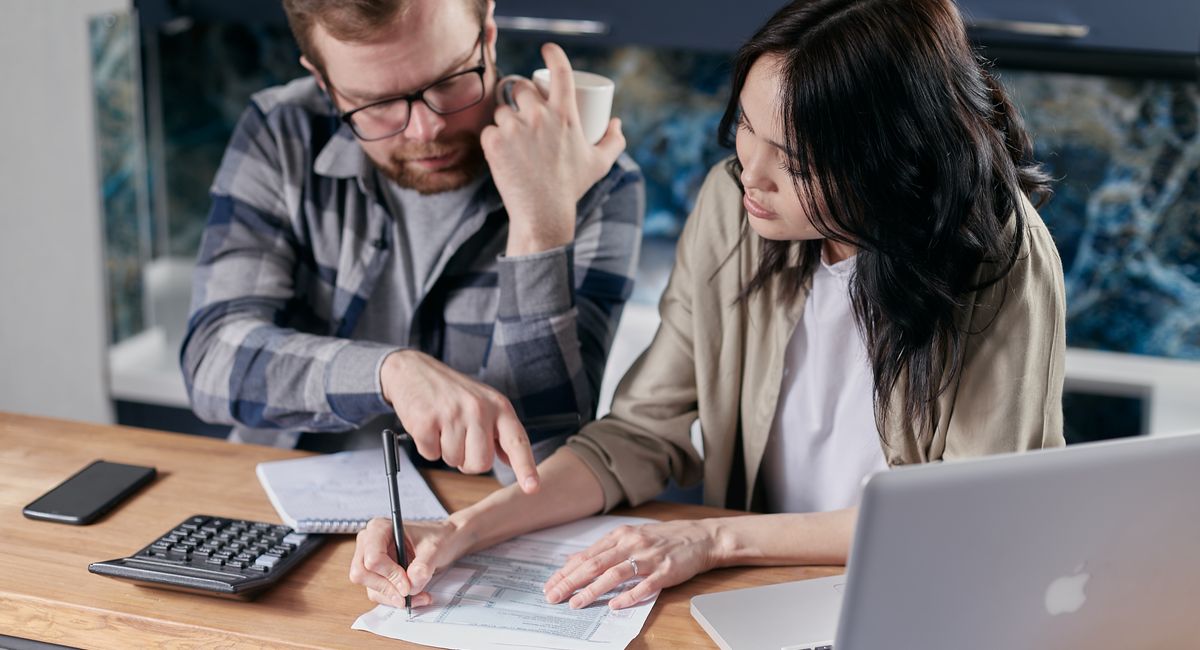 Couple étudiant des devis de travaux avec une calculatrice